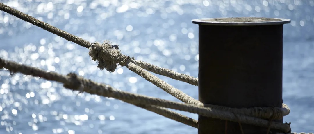 Tied rope around mooring pole in the port of Houston